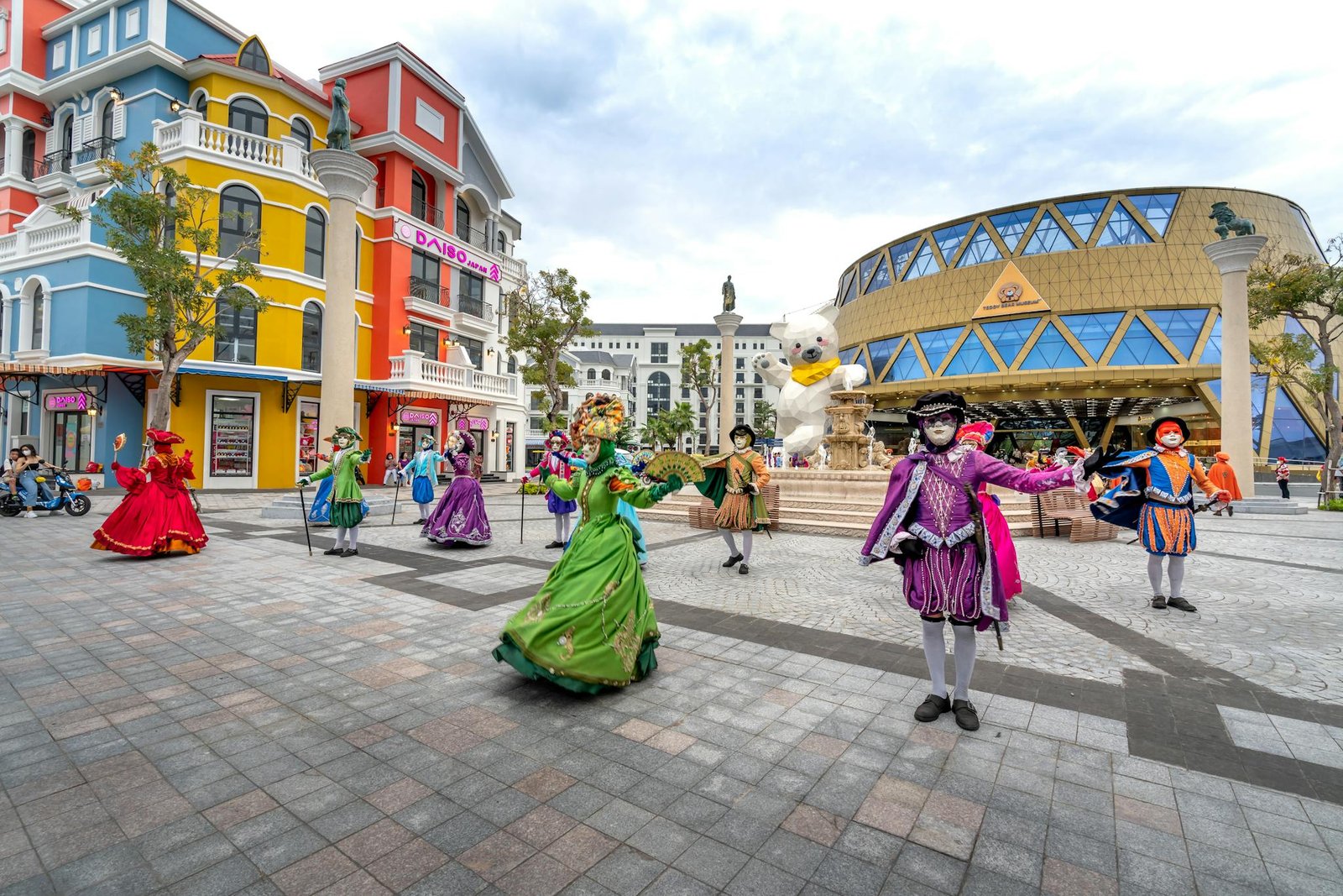 Vibrant masquerade performers in colorful costumes dancing on Phu Quoc street.
